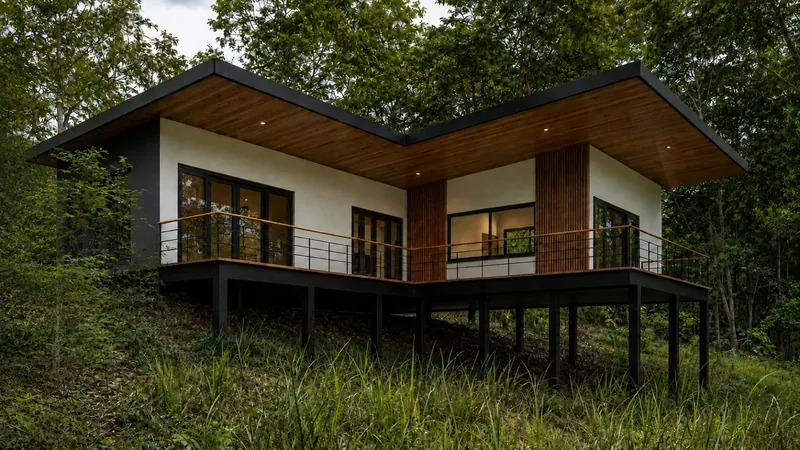 Residencia elevada entre árboles, con balcones y acabados de madera